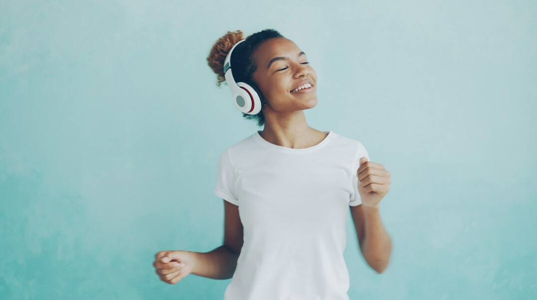 Smiling broadcast engineer woman wearing headphones in a control room